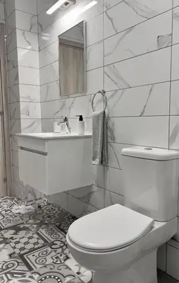 a white bathroom with a toilet and a mirror at Cosmos Residence in Paralimni