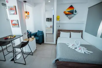 a bedroom with a bed and a table and a chair at Tsolias Apartments in Protaras