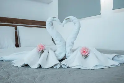 two white swan shaped towels on a bed at Tsolias Apartments in Protaras