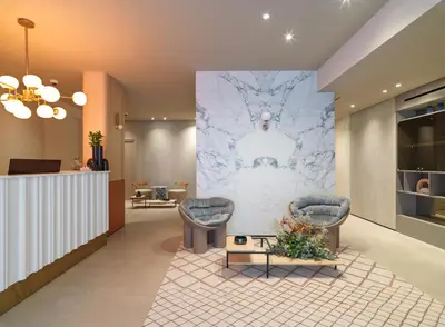 a lobby with two chairs and a wall mural at LIV Mackenzie Beach Suites Larnaca ADULTS ONLY in Larnaka