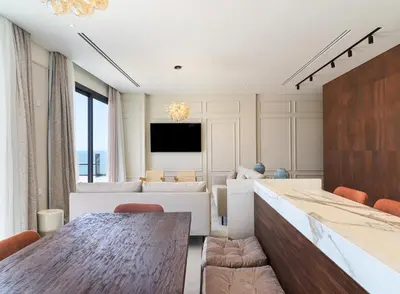 a living room with a table and a couch at LIV Mackenzie Beach Suites Larnaca ADULTS ONLY in Larnaka