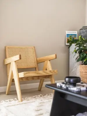 a wooden chair sitting in a living room at LIV Mackenzie Beach Suites Larnaca ADULTS ONLY in Larnaka