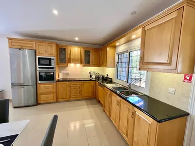 a kitchen with wooden cabinets and a stainless steel refrigerator at Dream Beachfront Bungalow in Limassol