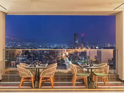 a restaurant with a view of a city at night at NYX Hotel Limassol in Limassol