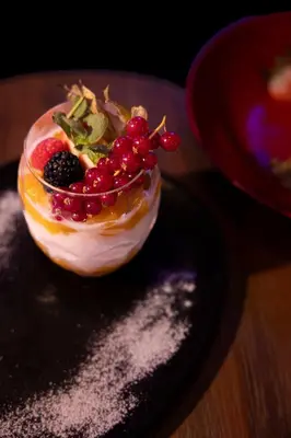 a dessert with fruit on a plate on a table at NYX Hotel Limassol in Limassol