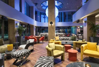 a lobby with colorful chairs and tables at NYX Hotel Limassol in Limassol
