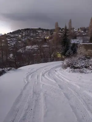 a snow covered road with tracks in the snow at Legacy 1930s in Prodromos