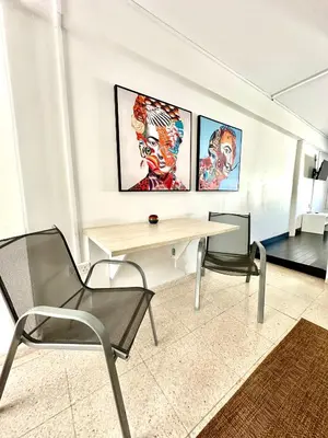 a table and two chairs in a room with paintings at Harbour Seaside Escape in Ayia Napa