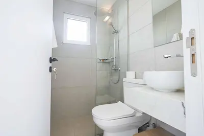 a white bathroom with a toilet and a sink at Nissi Kube KB1 in Ayia Napa