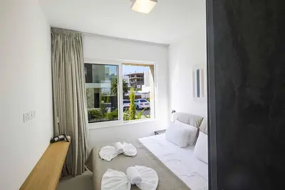 a bedroom with a bed and a window with bows at Nissi Kube KB1 in Ayia Napa