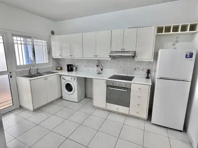 a white kitchen with a refrigerator and a dishwasher at Two Bedroom City Seaside Apartment in Limassol