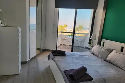 a bedroom with a large bed with a view of the ocean at Prime Beachfront Apartment on Larnaca Finikoudes in Larnaka