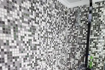 a bathroom with a shower with tiled walls at Prime Beachfront Apartment on Larnaca Finikoudes in Larnaka