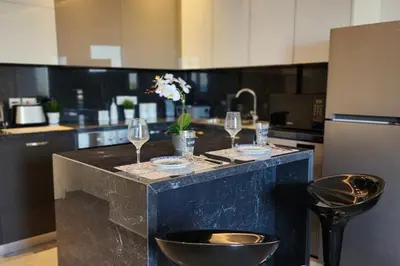a kitchen with a counter with wine glasses on it at Prime Beachfront Apartment on Larnaca Finikoudes in Larnaka