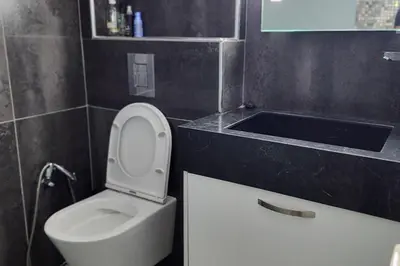 a bathroom with a white toilet and a sink at Prime Beachfront Apartment on Larnaca Finikoudes in Larnaka