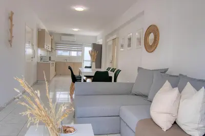 a living room with a gray couch and a kitchen at Phaedrus Living Down Town Flat Stephania 302 in Limassol