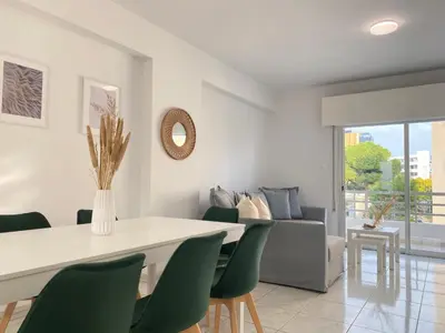 a dining room with a table and green chairs at Phaedrus Living Down Town Flat Stephania 302 in Limassol