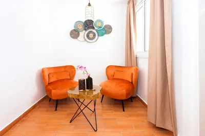two orange chairs and a table in a room at Villa White Star - 100m from Serena Beach in Protaras