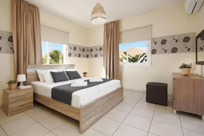 a bedroom with a large bed and a large window at Nissi Dreams Villa in Ayia Napa