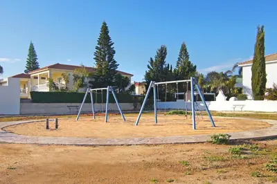 an empty playground with two swings in a park at Nissi Dreams Villa in Ayia Napa
