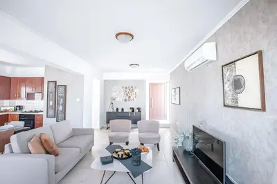 a living room with a white couch and a fireplace at Blue Crystal Seaview in Protaras