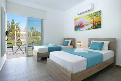 a bedroom with two beds and a balcony at Villa Catalina in Ayia Napa