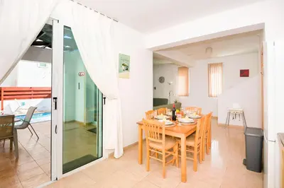 a dining room and living room with a table and chairs at Villa Mandy in Protaras
