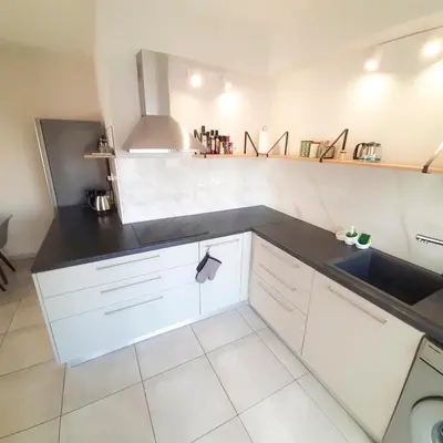 a kitchen with white cabinets and a black counter top at Sea Breeze Central, 2bed in Limassol