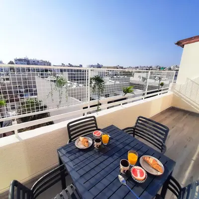 a blue table with food and drinks on a balcony at Sea Breeze Central, 2bed in Limassol