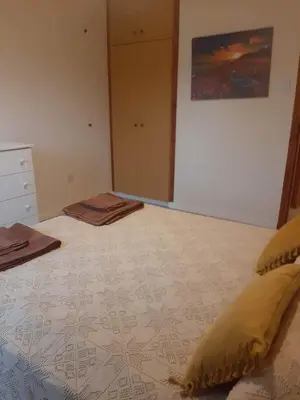 a bedroom with a bed with a painting on the wall at Klimataria B2 in Pissouri