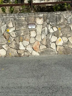 a stone retaining wall with a sign on it at Klimataria B2 in Pissouri