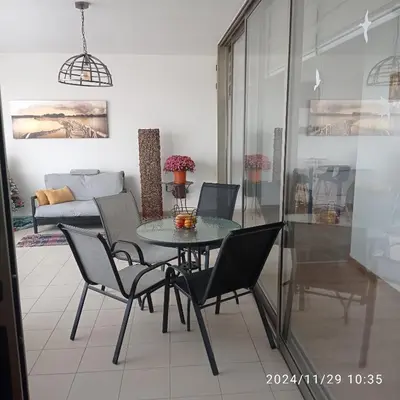 a dining table and chairs in a living room at Anamor apartment 408 in Larnaka