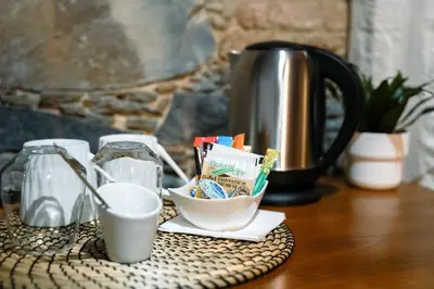a table with a coffee pot and a bowl of sugar at Archontiko Rousias in Nicosia