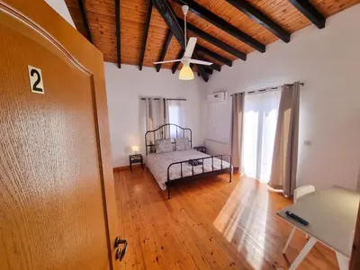 a bedroom with a bed and a ceiling at Mountains Retreat Rooms & Suites in Ayios Theodhoros