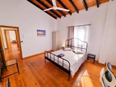 a bedroom with a bed and a wooden floor at Mountains Retreat Rooms & Suites in Ayios Theodhoros