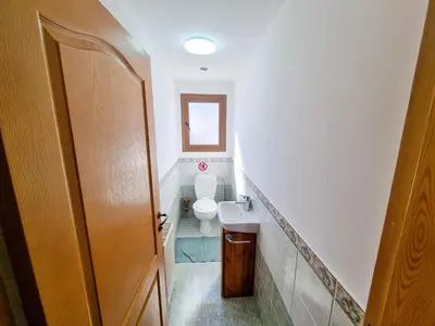 a small bathroom with a toilet and a sink at Mountains Retreat Rooms & Suites in Ayios Theodhoros