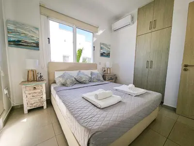a bedroom with a bed with two towels on it at Nissi beach villa Magnolia in Ayia Napa