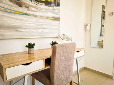 a desk in a room with a painting on the wall at Nissi beach villa Magnolia in Ayia Napa