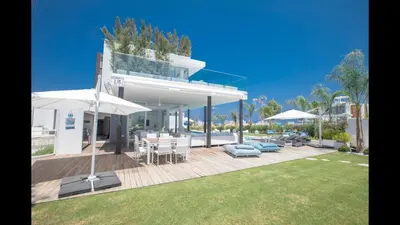 a house with a deck with a table and umbrellas at Protaras Olivine Villa Ol3 in Protaras