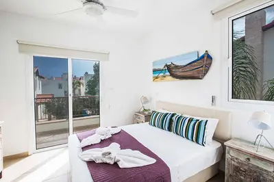 a white bedroom with a bed and a window at Villa Pepper in Protaras