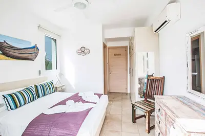 a white bedroom with a bed and a chair at Villa Pepper in Protaras