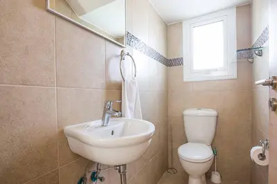 a bathroom with a sink and a toilet and a mirror at Villa Pepper in Protaras