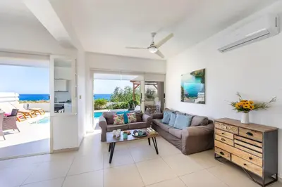 a living room with a couch and a table at Protaras Artisan Seafront Villa 1 in Protaras