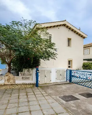 a house with a white fence and a tree at Protaras Artisan Seafront Villa 1 in Protaras