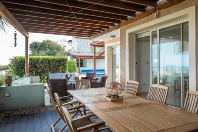 a wooden table and chairs on a patio at Protaras Artisan Seafront Villa 7 in Protaras