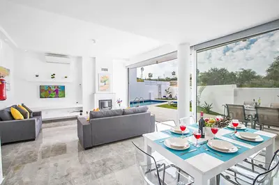 a living room with a white table and chairs at Villa Macan in Protaras