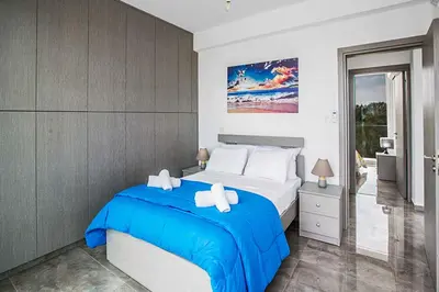 a bedroom with a bed with a blue blanket at Villa Macan in Protaras