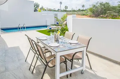 a white table and chairs on a patio at Villa Macan in Protaras
