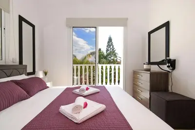 a bedroom with a bed with towels and a balcony at Nissi Sapphire Villa in Ayia Napa