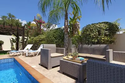 a patio with chairs and a swimming pool at Nissi Adamite Villa in Ayia Napa